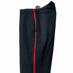 Black wool dress trousers with red piping on a white background