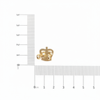 Gold crown badge with ruler for scale on white background