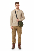 Male traveller model wearing the small camo canvas messenger bag on a white background