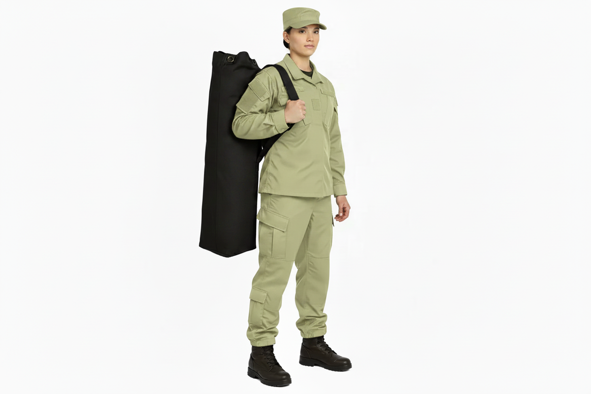 Model with lighter olive-sand clothing and unchanged black kit bag